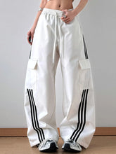 White cargo pants with black striped wide leg three stripes down the sides and large flap pockets