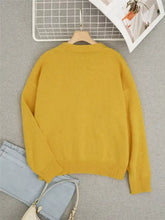 Bee embroidered yellow knit cardigan on wooden hanger