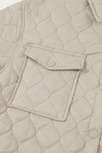 Beige quilted jacket with khaki high collar, pockets, and button closure