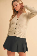 Cream-colored ribbed hem button cardigan with knit pockets