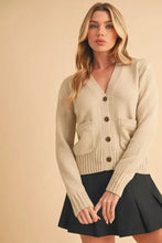Beige cardigan with ribbed hem button closure and knit pockets