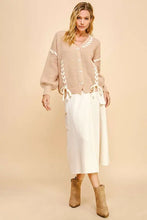 Beige chunky knit cardigan with lace-up ribbon bow, white skirt, brown boots