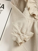 Cream-colored textured collared neck dress with ruffled bow