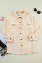 Beige corduroy button-down utility jacket with chest pockets and rolled sleeves