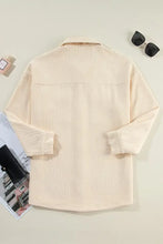 Beige corduroy button-down utility jacket with pockets, long sleeves, and classic collar