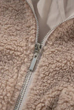Close-up of silver zipper on beige faux fur teddy bear jacket fabric
