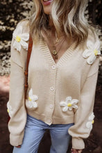 Beige floral cardigan sweater with white and yellow flowers, buttons, and ribbed cuffs
