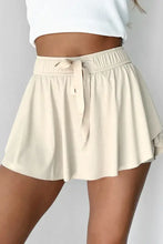 Beige high-waisted shorts with drawstring waistband from pleated tennis skirt collection