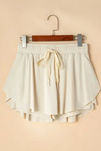 Cream-colored high-waisted pleated tennis skirt shorts