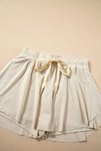 Cream-colored high-waisted cotton shorts with elastic waist and drawstring from pleated tennis skirt collection