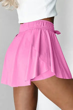 Pink pleated tennis skirt with bow detail and high-waisted shorts