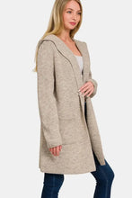 Beige hooded open sweater cardigan with textured wool, pockets, and fur trim