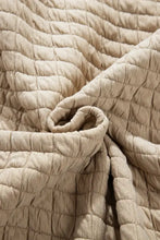Beige quilted jacket with seam collared neck button and plush throw blanket texture