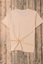 Cream-colored short sleeve t-shirt with fall candy heart graphics and back knot detail