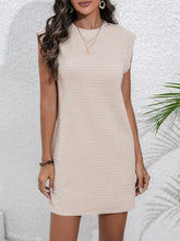 Beige textured mini dress with short sleeves, high neckline, pockets, and layered necklaces