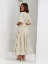 Beige tiered midi dress in cream-colored linen with ruffled hem and puff sleeves