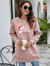 Dusty pink crew neck graphic tunic sweatshirt with Santa hat and Believe graphic