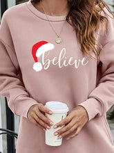 Pink long-sleeved BELIEVE graphic tunic sweatshirt with Santa hat