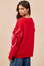 Back view of red bi bi bow detail sleeves fleece sweatshirt in fleece blend with white embroidered bow and pairing tips
