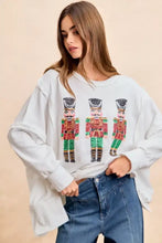 White oversized sweatshirt with sequin nutcrackers embroidery in red green and gold by bibi christmas collection