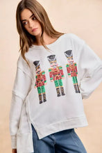 White oversized sweatshirt featuring red green and gold sequin nutcrackers embroidery by bibi christmas collection