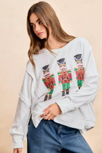 White oversized cut long-sleeved sweatshirt with red green and gold sequin nutcrackers embroidery by bibi christmas