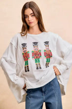 White oversized cut long-sleeved sweatshirt with sequin nutcrackers embroidery in red green and gold by bibi
