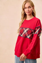 Red long-sleeved sweatshirt with a plaid patch on the chest and sleeves.