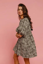 A woman wearing a bi bi leopard denim dress with puffed sleeves and back contrast tie detail in black and white