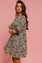 Women wearing a black and white leopard print a-line denim dress with long sleeves and back contrast tie detail