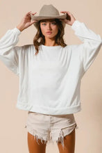 White oversized sweatshirt with relaxed fit ribbed cuffs made from loop terry featuring a cut edge band