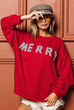 Red long-sleeved sweater with merry in silver glitter lettering featuring a relaxed drop shoulder design by bibi