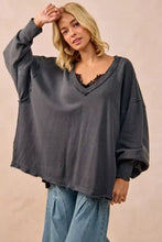 BiBi mineral washed french terry oversized sweatshirt in dark gray with v-neck and frayed hem paired with white sneakers
