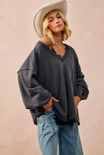 Dark gray BiBi mineral washed french terry oversized sweatshirt with v-neck and distressed hem styled with white sneakers