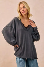 Dark gray oversized BiBi mineral washed french terry sweatshirt with v-neck and frayed hem worn over black lace