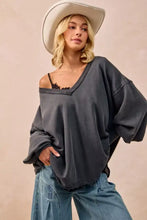 Dark gray oversized sweatshirt with v-neck off-the-shoulder design in french terry fabric paired with white sneakers