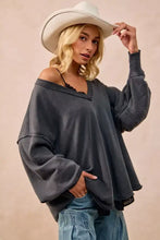Dark gray oversized sweatshirt in french terry with frayed edges and off-the-shoulder relaxed fit styled with white sneakers