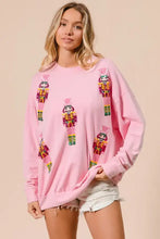 Pink long-sleeved bibi sequin nutcrackers sweatshirt with deep green embroidered sequin nutcrackers design for christmas