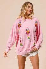Pink oversized sweatshirt with colorful bibi sequin nutcrackers embroidery for festive christmas wear