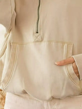 Cream-colored bi bi stitch detailed half zip fleece hoodie with quilted zipper pull and elastic hem trim