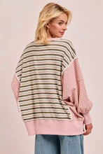 A soft pink and olive green bibi stripe oversized sweater with cut edge detail and reverse outseam for relaxed fit