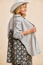 A woman wears a BiBi stripes jacquard floral mix and match shirt top with gray stripes and black floral print