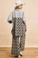 A woman wearing a BiBi stripes jacquard floral mix and match shirt top with vertical stripes and black and white floral print