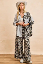 Woman wearing a light blue striped bi bi stripes jacquard floral mix and match shirt top with floral wide-leg pants and white cowboy hat