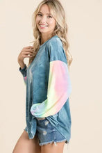 BiBi tie dye french terry top with faded blue body and vibrant rainbow tie dye sleeves paired with distressed denim shorts