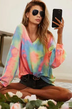 A vibrant pastel rainbow tie dye french terry blouse with long sleeves v neck and a slightly oversized fit