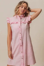 A soft pink denim dress featuring bibi washed button details and delicate ruffled cap sleeves at collar and shoulders