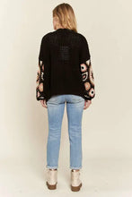 Black and pink floral crochet cardigan by Free People with jeans and boots