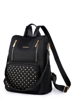 Black beaded backpack with gold zipper pocket and studded front
