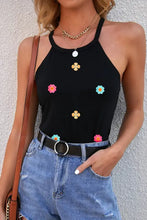 Black floral embroidered crop top with thin straps and gold accents
